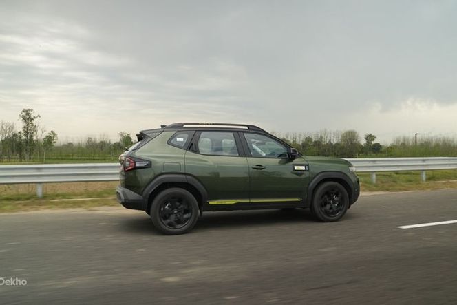 Renault Duster in green driving on a highway, side view with black wheels. Renault Duster in green driving on a highway, side view with black wheels.