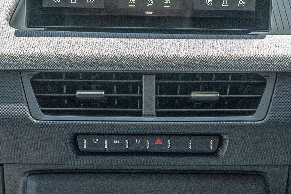 Tata Tiago central AC vents above a row of switches on a fabric-wrapped dashboard