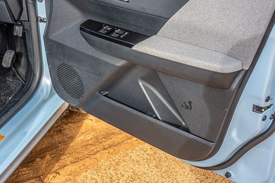 Tata Tiago driver door panel with window switches, fabric armrest, speaker and bottle pocket.