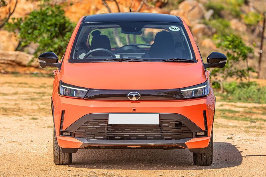 Tata Tiago front view in orange with black roof and slim LED headlamps