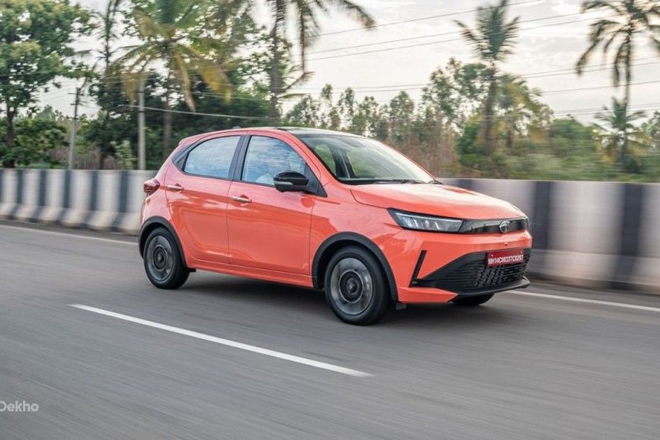 Tata Tiago in orange driving on a highway, front three-quarter view
