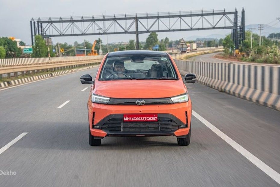 Tata Tiago in orange driving towards the camera on a highway