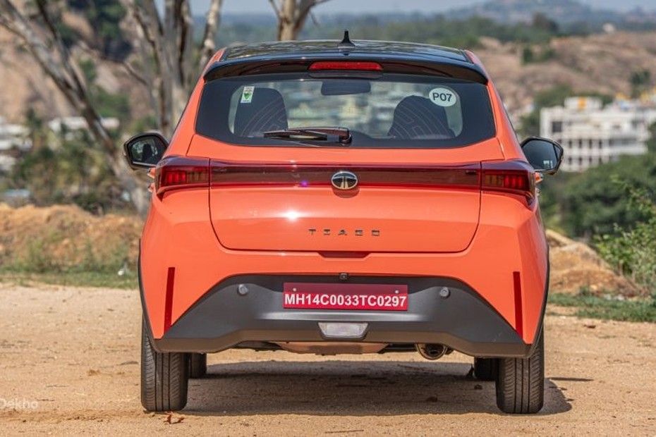 Tata Tiago in orange seen from the rear, parked on a dirt ground