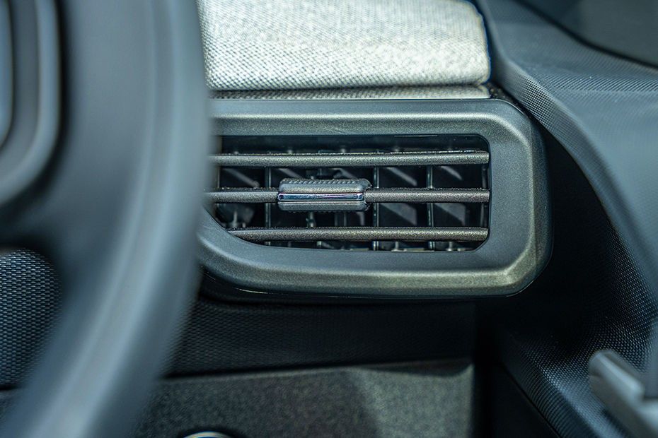 Tata Tiago driver side AC vent with chrome adjuster below fabric dashboard trim
